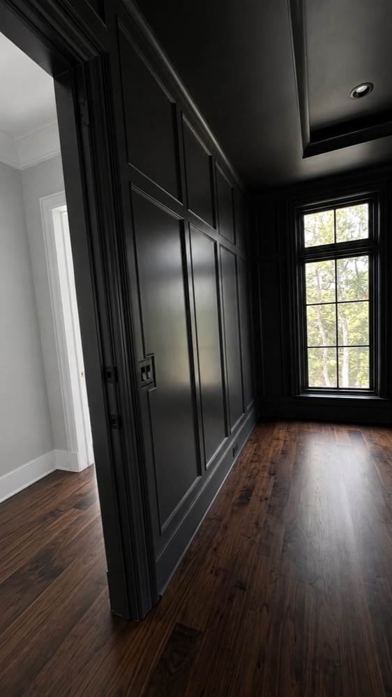 Hallway with painted black wall paneling